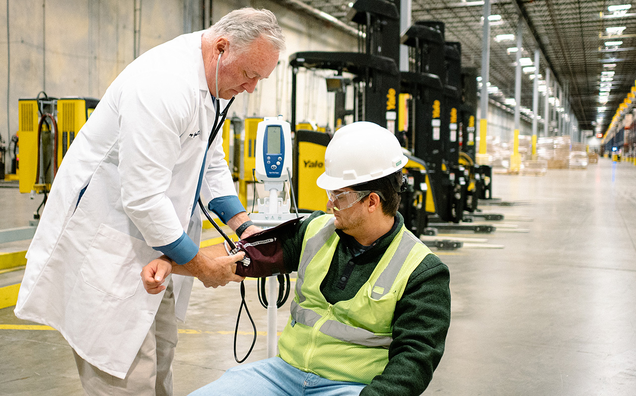 Medical provider conducting a blood pressure test on an employee